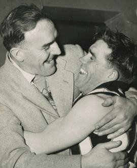 Phonse Kyne embraces Lou Richards after Collingwood secures the 1953 Flag.