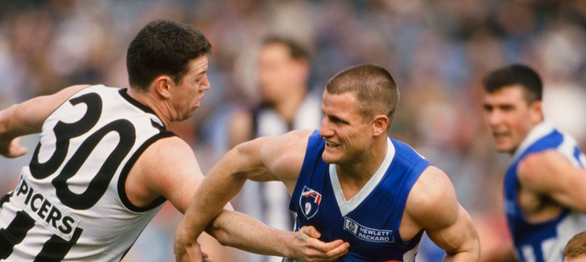 Paul Sharkey tries to latch onto Robert Scott during Collingwood's win over North Melbourne in round 22, 1997.
